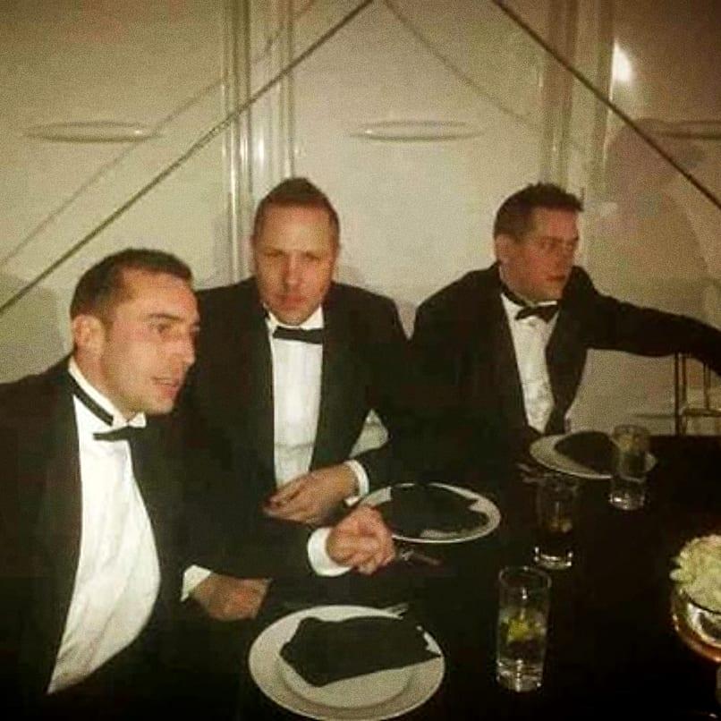 Three men in black tie at a dinner table in Dubai