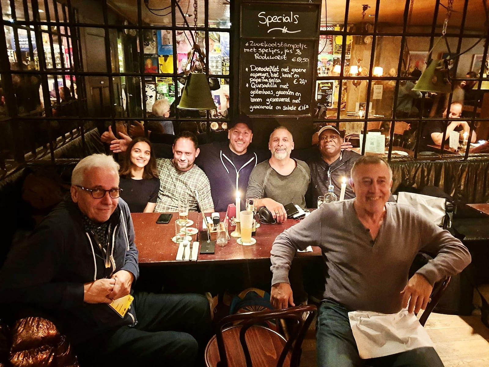 A table of friends at dinner in a candlelit bar, Matt in the middle