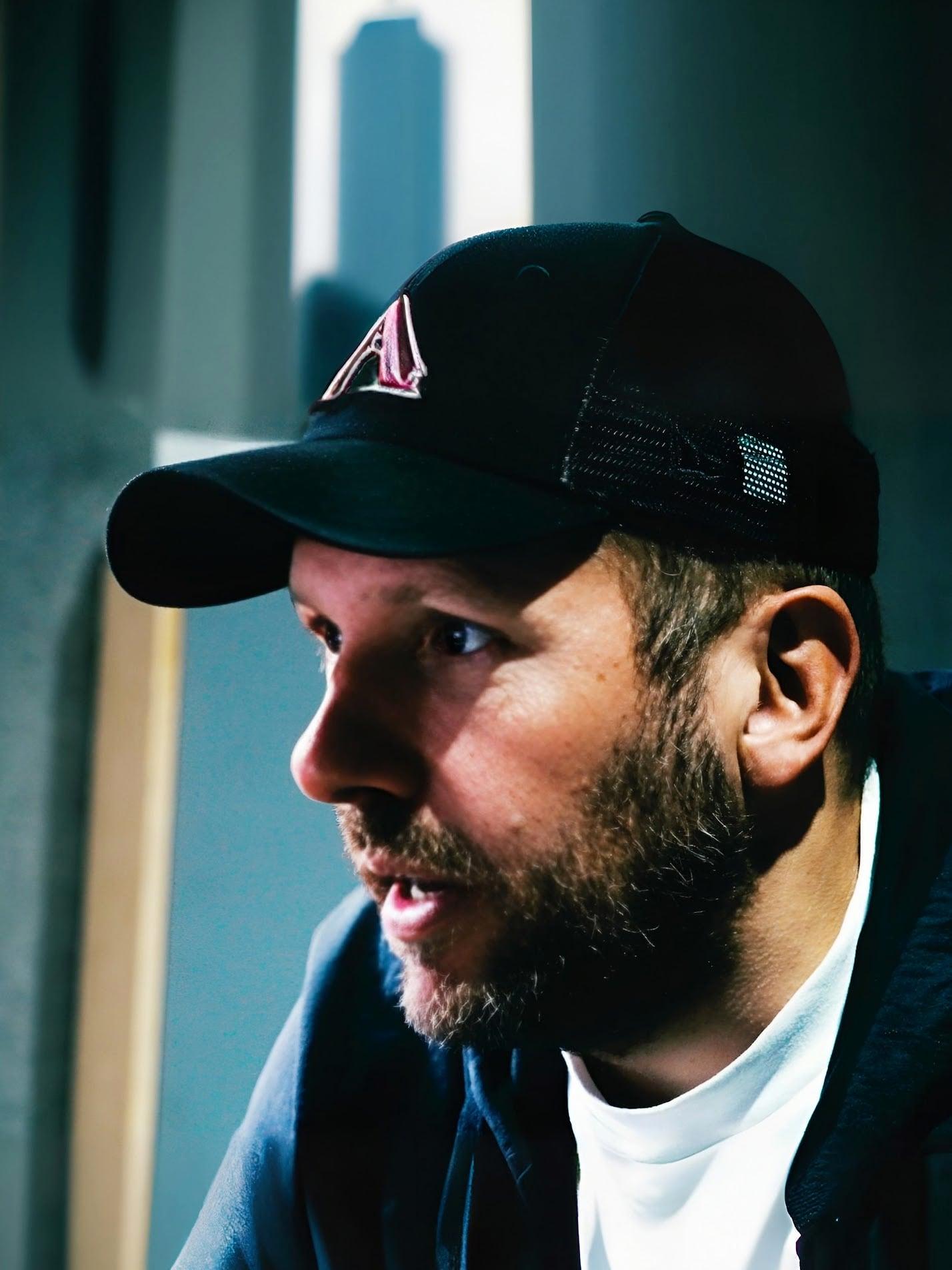 Matt in an Audiofreaks cap, leaning in towards a screen in the studio