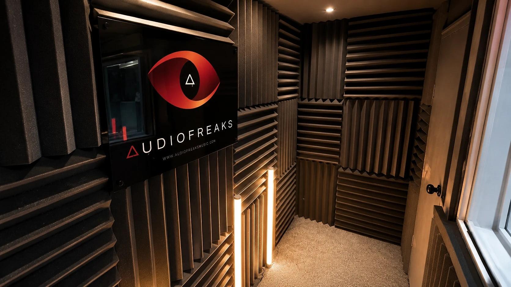The vocal booth: acoustic foam, warm light and the Audiofreaks sign